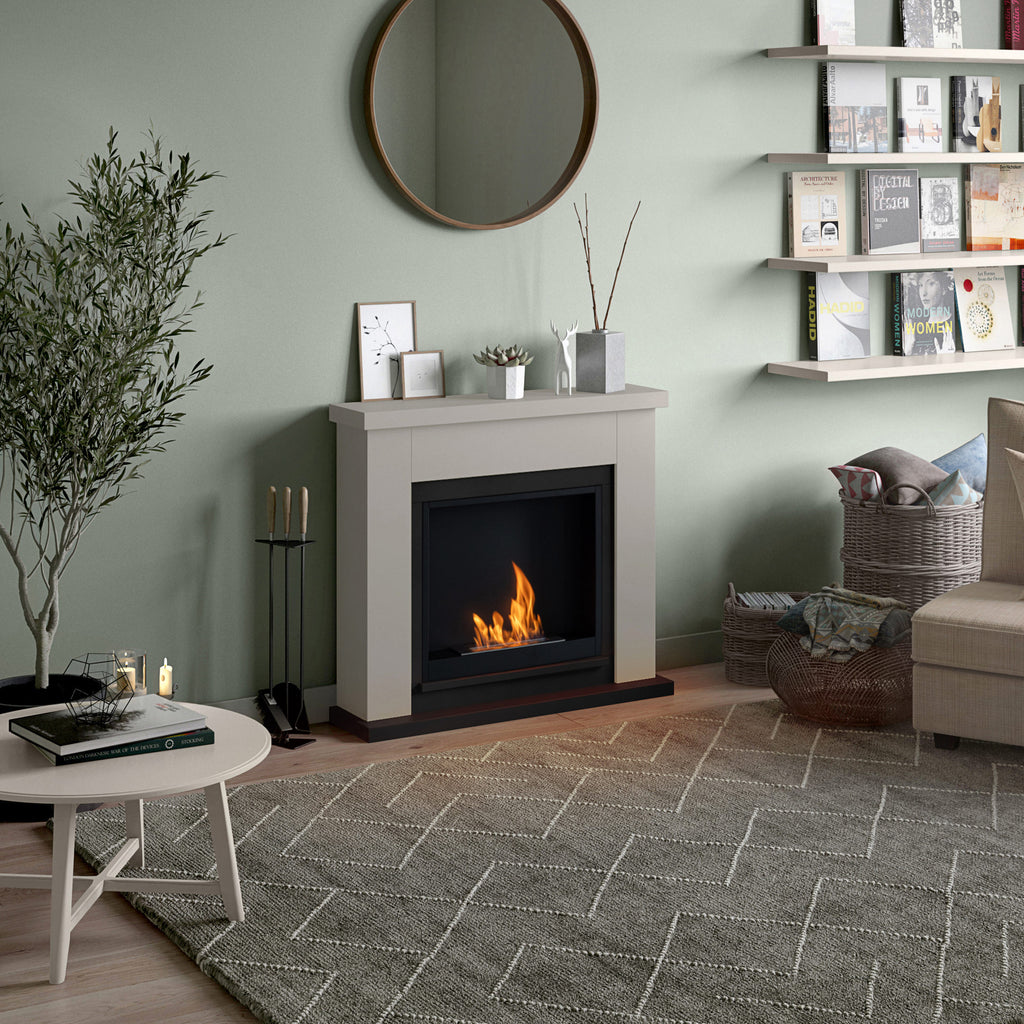 Living room with a fireplace, round mirror, and decorative items.